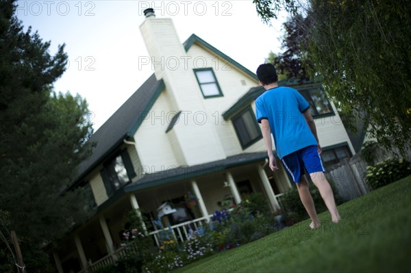 Young boy walking towards house. Photo : Tim Pannell
