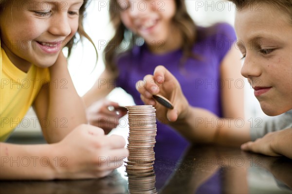 Children stacking coins. Photo : Tim Pannell