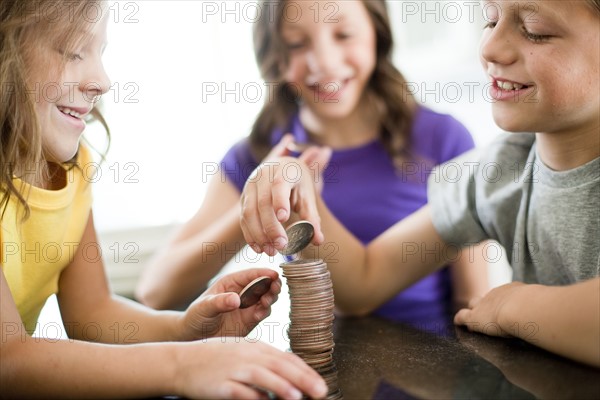 Children stacking coins. Photo : Tim Pannell