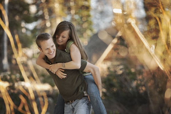 Man giving girlfriend a piggyback ride. Photo. FBP