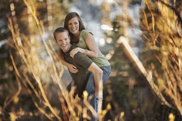 Man giving girlfriend a piggyback ride. Photo. FBP