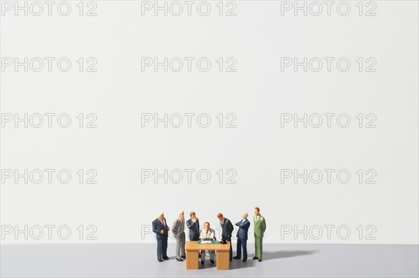 Figurines of people standing around desk. Photo : Antonio M. Rosario