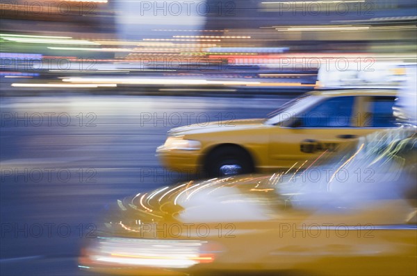 Taxi cabs driving at night. Photo. Antonio M. Rosario