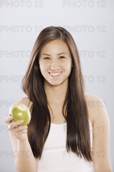 Brunette woman holding an apple. Photo : FBP