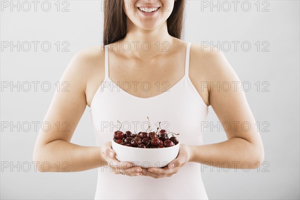 Woman holding a bowl of cherries. Photo : FBP