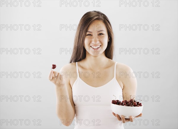 Woman holding a bowl of cherries. Photo. FBP