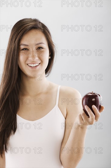 Woman holding a red apple. Photo : FBP
