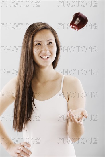 Woman tossing a red apple. Photo : FBP