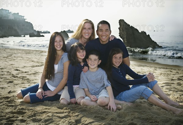 Family sitting together at the beach. Photo : FBP