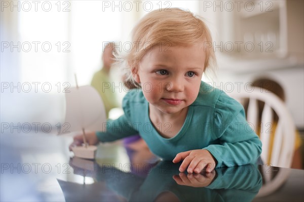 Young girl playing with toy boat. Photo : Tim Pannell