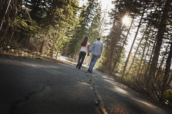 Couple walking hand in hand on a country road. Photo. FBP