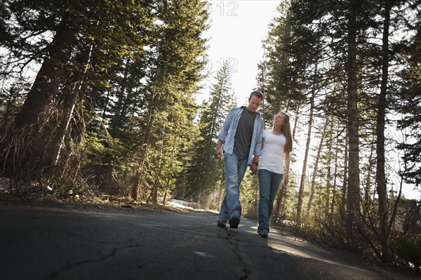 Couple walking hand in hand on a country road. Photo. FBP