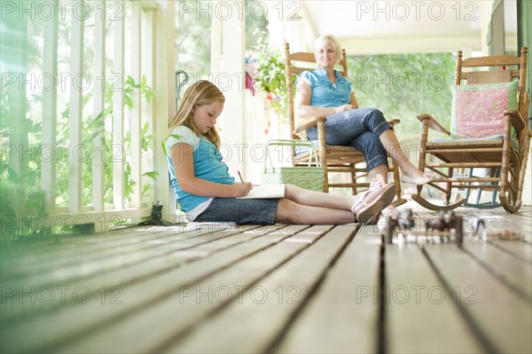 Mother and daughter relaxing on porch. Photo. Tim Pannell