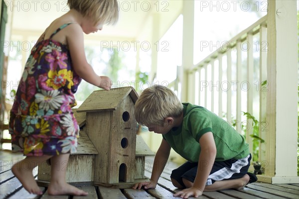 Brother and sister looking at birdhouse. Photo : Tim Pannell