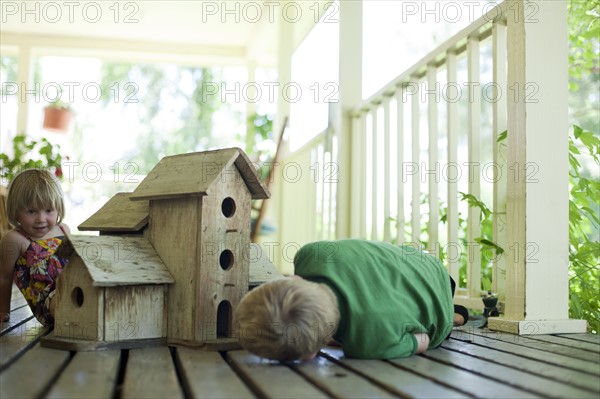 Brother and sister looking at birdhouse. Photo. Tim Pannell