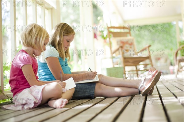 Two girls writing letters. Photo : Tim Pannell