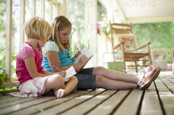 Two girls writing letters. Photo : Tim Pannell