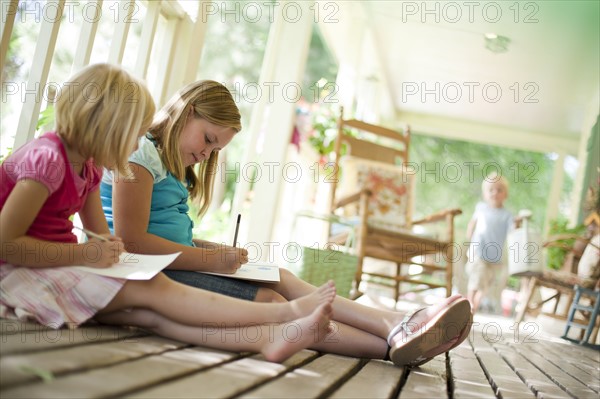 Two girls writing letters. Photo : Tim Pannell