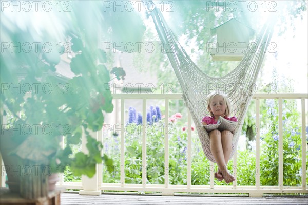 Young girl reading in hammock. Photo : Tim Pannell