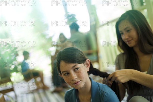 Mother braiding her daughter's hair. Photo : Tim Pannell