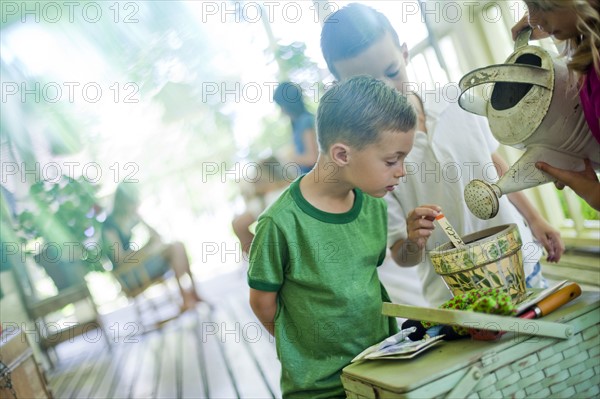 Young children watering seeds in a planter. Photo : Tim Pannell