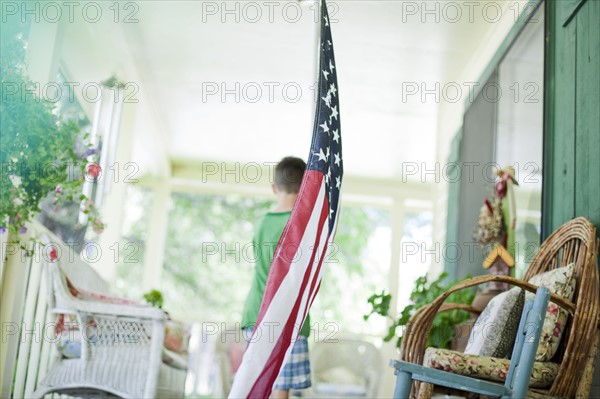 Young boy carrying American flag. Photo : Tim Pannell