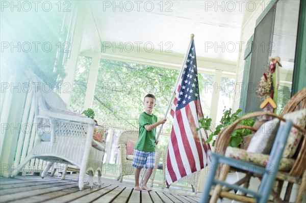 Young boy carrying American flag. Photo : Tim Pannell
