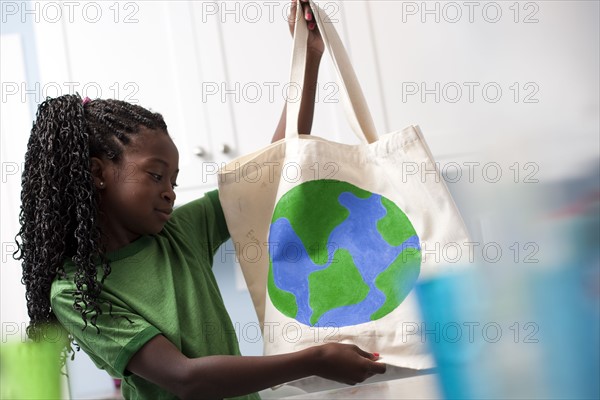 Young girl holding reusable shopping bag. Photo : Tim Pannell