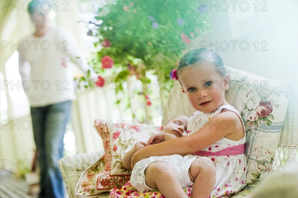 Young girl holding her baby sister. Photo : Tim Pannell