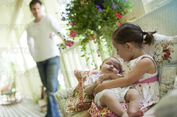 Young girl holding her baby sister. Photo : Tim Pannell