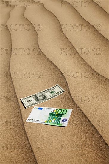 Money on sand in desert. Photo : Mike Kemp