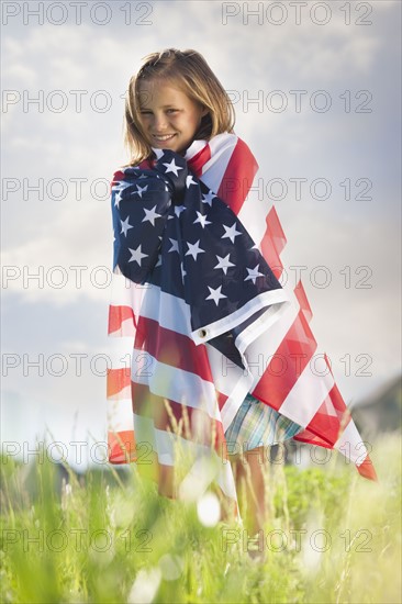 Young girl draped in American flag. Photo : Mike Kemp
