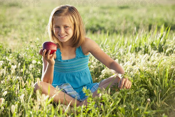 Young girl eating an apple. Photo : Mike Kemp