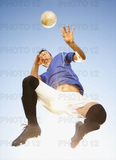 Soccer player heading the ball. Photo : Mike Kemp