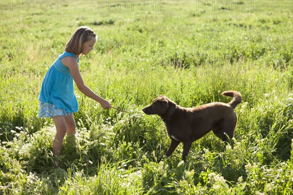 Young girl playing with her dog. Photo : Mike Kemp