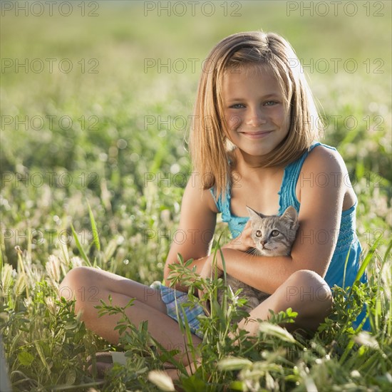 Young girl holding a kitten. Photo. Mike Kemp