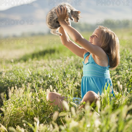 Young girl holding a kitten. Photo. Mike Kemp