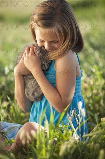 Young girl holding a kitten. Photo : Mike Kemp