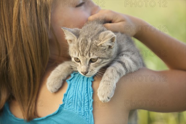 Young girl holding a kitten. Photo. Mike Kemp