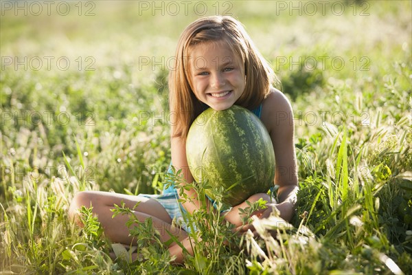 Young girl holding a watermelon. Photo : Mike Kemp