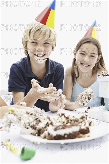 Children eating birthday cake with their hands. Photo : momentimages