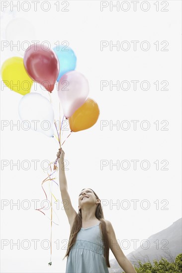 Young girl holding balloons. Photo. momentimages