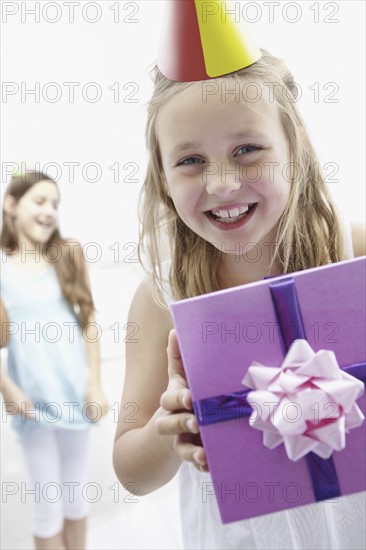 Birthday girl holding a gift. Photo. momentimages