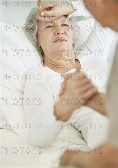 Man caring for senior woman with a headache. Photo. momentimages