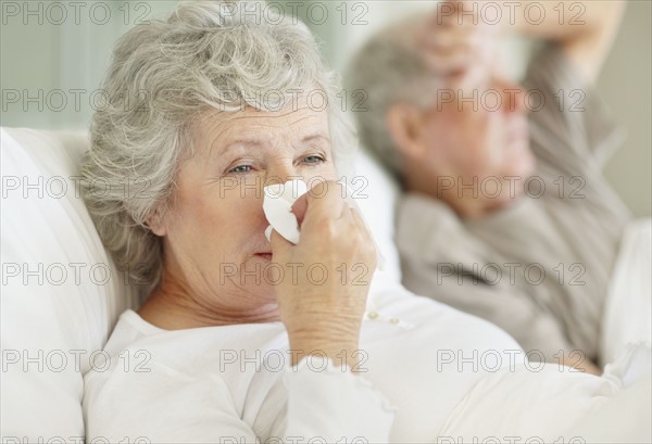 Senior couple in bed with the flu. Photo : momentimages