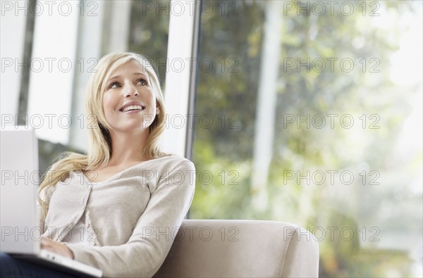 Attractive blond woman daydreaming. Photo : momentimages