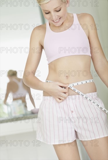 Sexy woman measuring her waist. Photo : momentimages