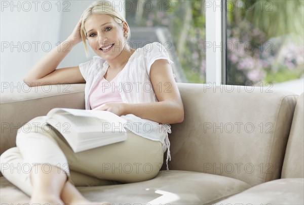 Pretty blond woman reading a book. Photo : momentimages