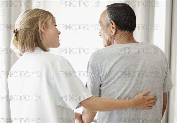 Nurse assisting patient with a walker. Photo : momentimages