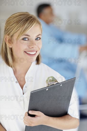 Nurse holding a clipboard. Photo : momentimages